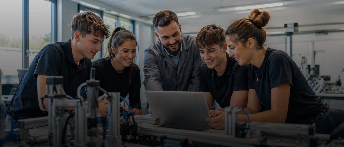 Grupo de estudiantes de FP colaborando con un profesor